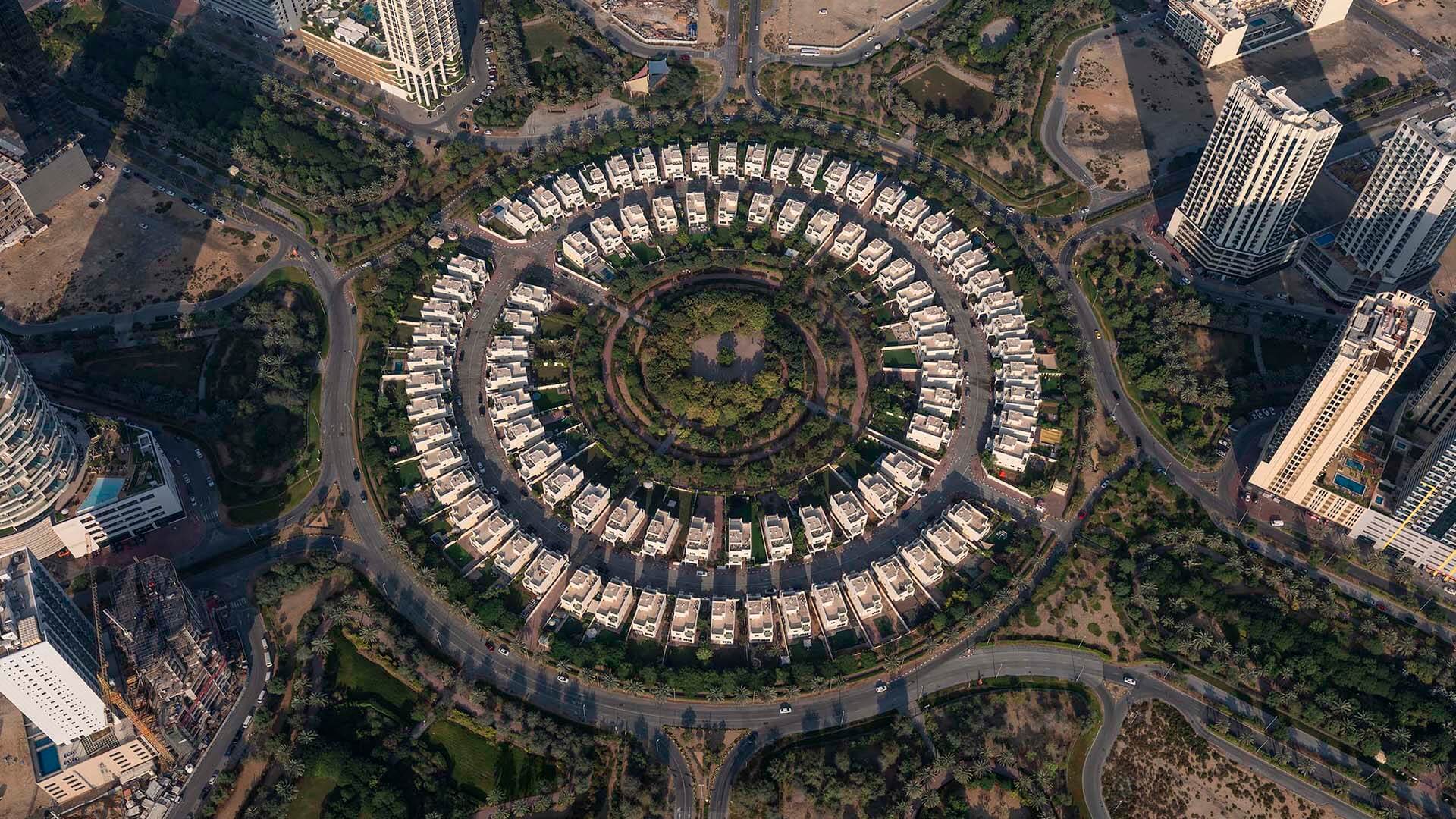 dubai secondary market 2026 — Jumeirah Village Circle aerial view showing mid-market apartment buildings